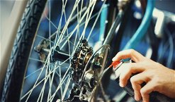 applicazione dello spray lubrificante sugli ingranaggi di una bicicletta
