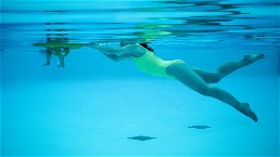 donna che nuota in piscina ripresa subacquea