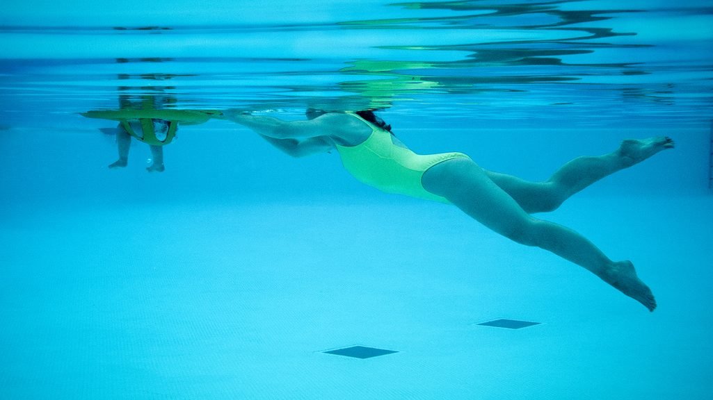 donna che nuota in piscina ripresa subacquea