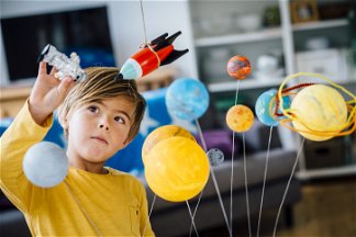 bambino che gioca con sistema solare giocattolo