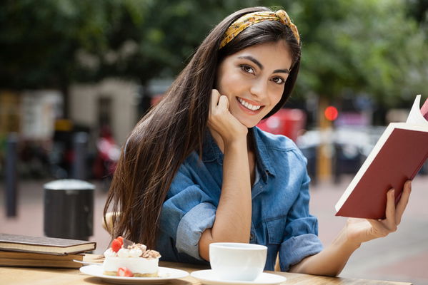 ragazza con fascia capelli che legge un libro