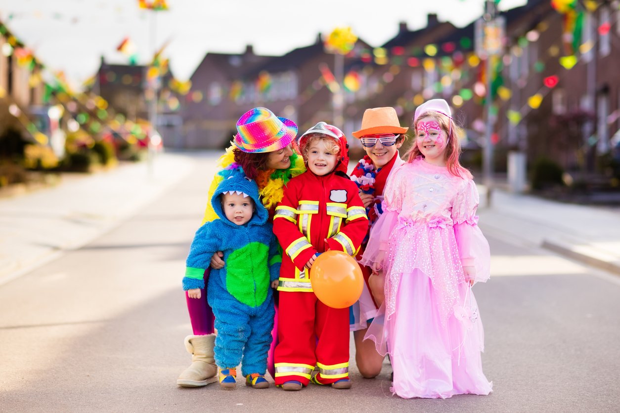 5 bambini vestiti per carnevale in una strada residenziale