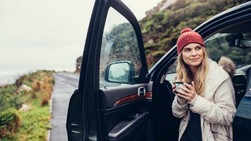 ragazza che beve caffè fuori dalla macchina