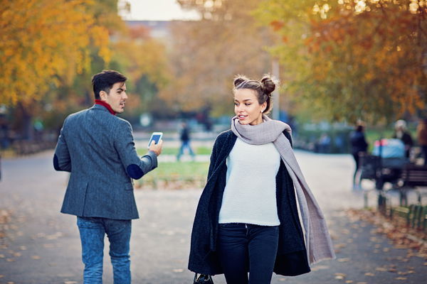 uomo che guarda donna camminare nel parco autunnale