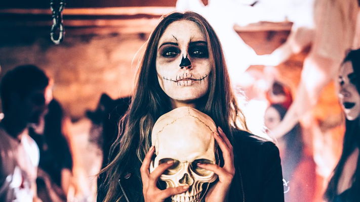 Ragazza vestita da Halloween ad una festa con un teschio tra le mani