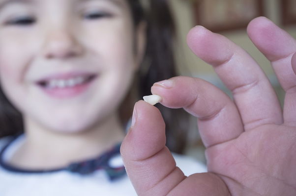 bambina con dentino in mano