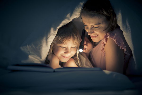 mamma con bambina con lampada libro