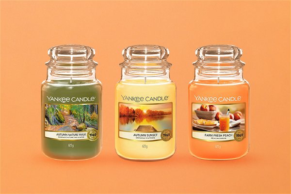 yankee candel con profumazioni autunnali su sfondo arancio