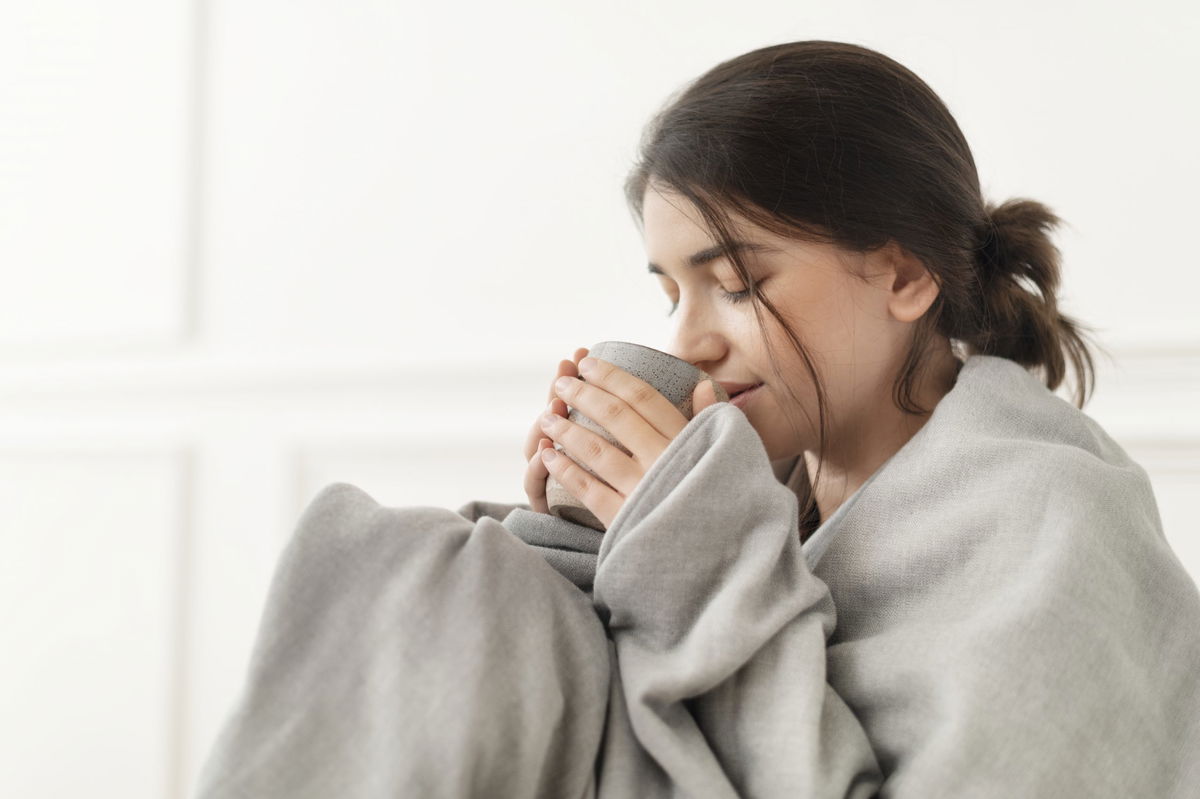 ragazza che beve caffe con coperta 