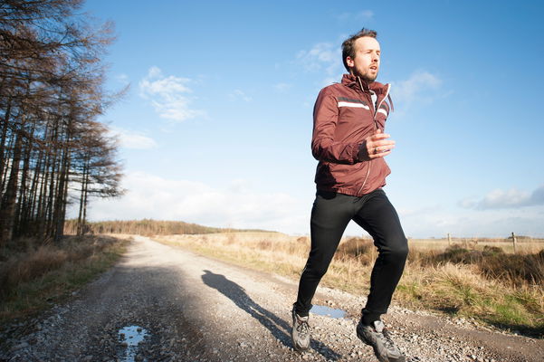 Uomo che corre su una strada sterrata