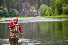 Uomo che pesca a mosca dentro il fiume