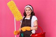 donna con strumenti da pulizia della casa su sfondo rosa