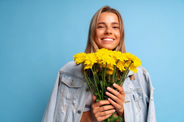 Ragazza che tiene in mano un mazzo di fiori gialli