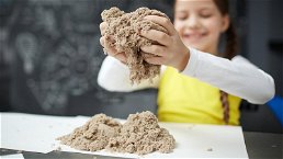 bambina che gioca con la sabbia cinetica