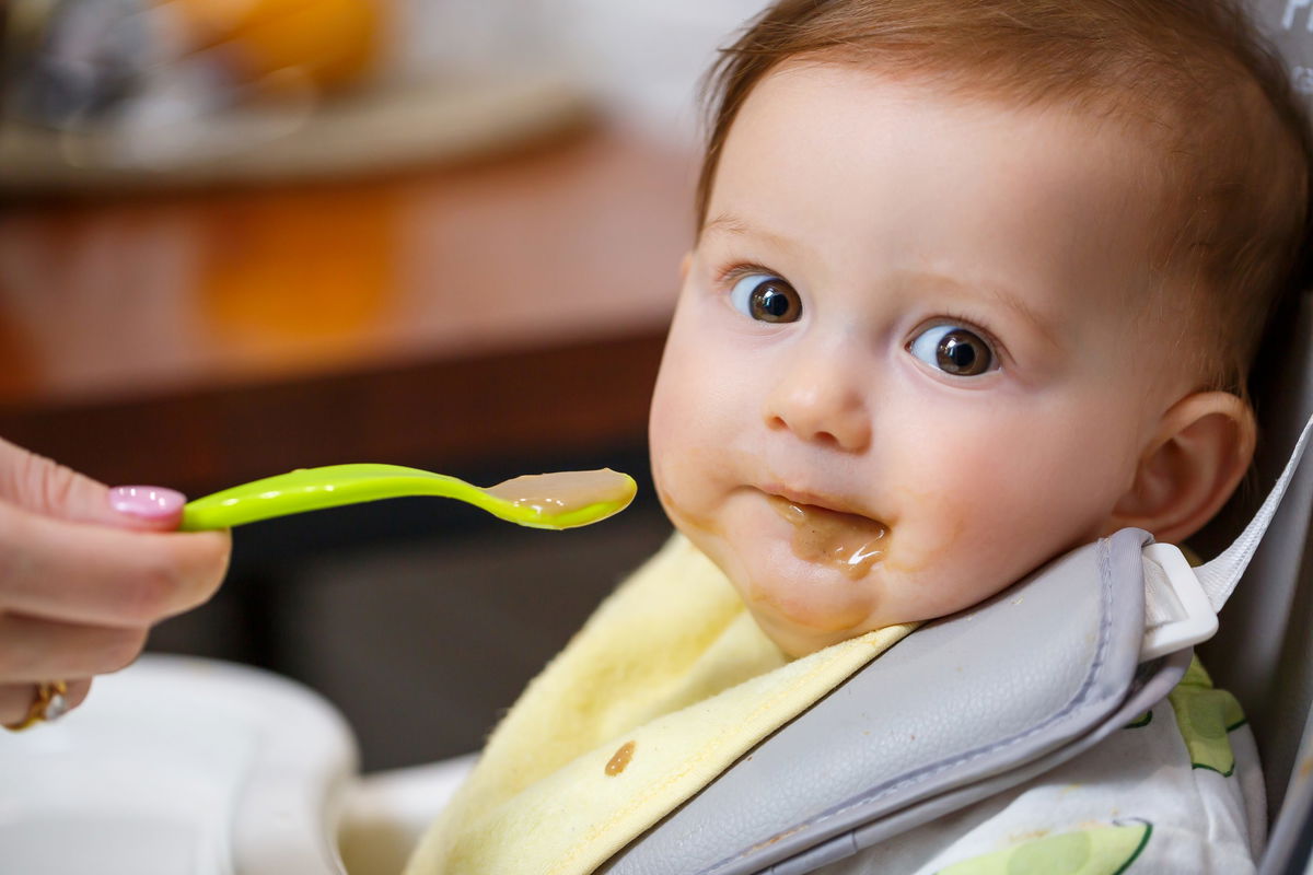 bambino che mangia su seggiolone portatile