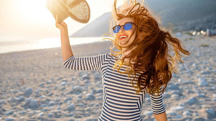 ragazza sulla spiaggia con i capelli al vento