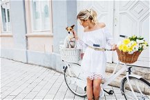 ragazza con abito bianco in pizzo sulla bicicletta